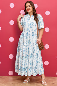 Robe ample bleu ciel à motifs floraux, col haut boutonné, silhouette évasée.