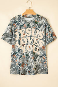 T-shirt gris clair à imprimé « JESUS LOVE » sur fond abstrait, manches courtes