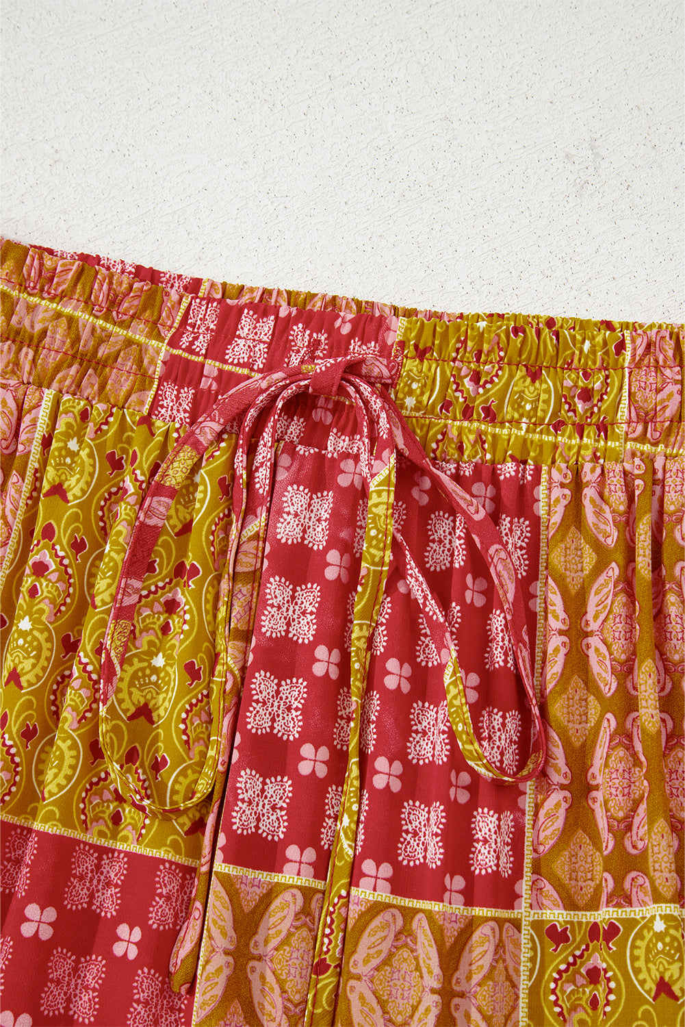 Jupe maxi à volants, ceinture élastique avec lien noué, motifs paisley jaune et rouge