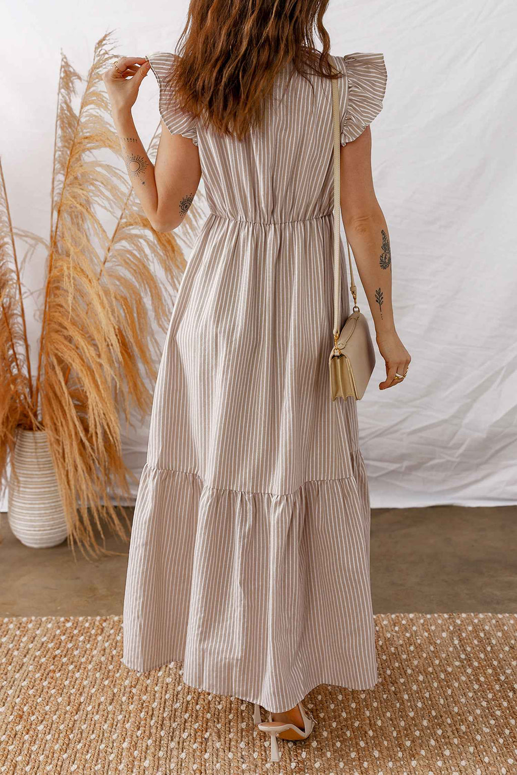 Robe longue rayée avec manches volantées, col V et boutons sur toute la longueur.