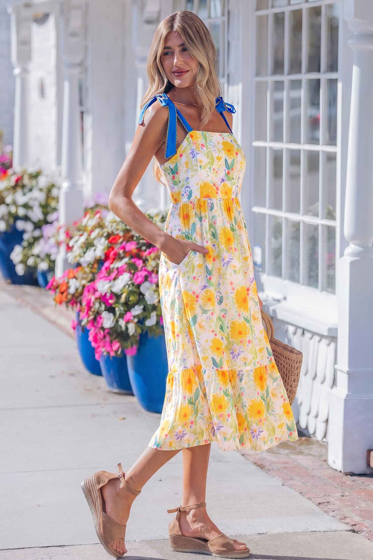 Robe midi imprimé floral jaune, bretelles avec nœuds bleus, volant évasé en bas.