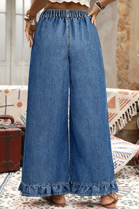 Pantalon jean bleu ample, ceinture froncée, bas volanté et jambes très larges