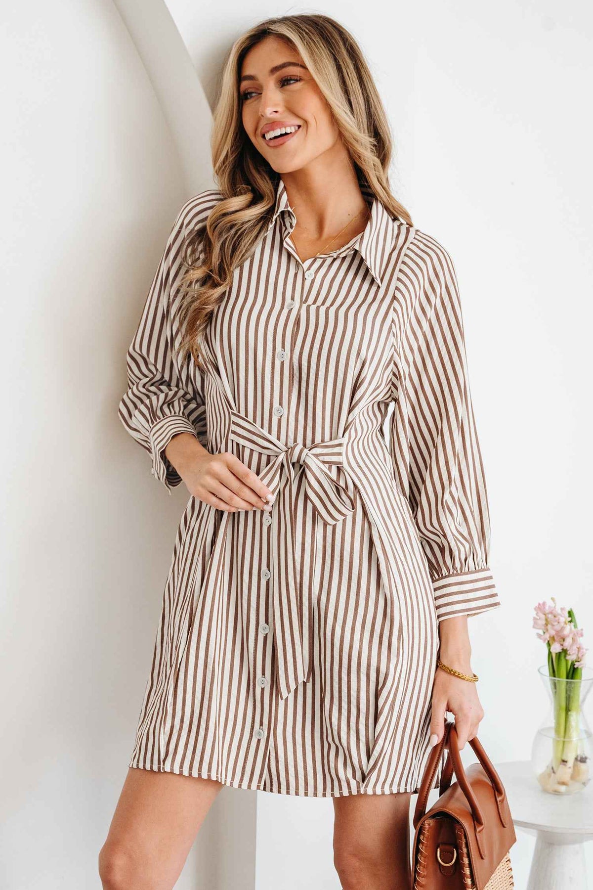 Robe chemisier rayée brune, col chemise, nœud à la taille, manches bouffantes.
