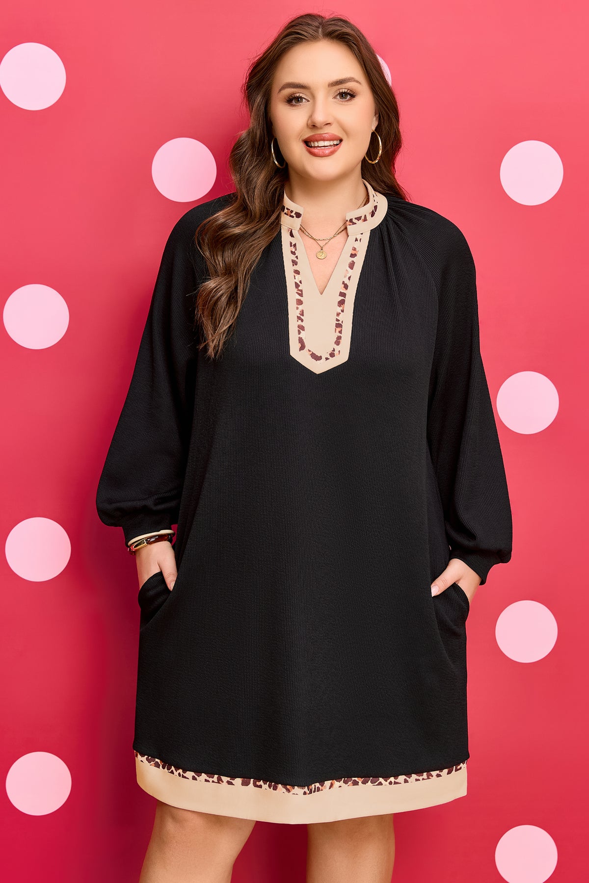 Robe mini noire avec col en V bordé, manches bouffantes, ourlet à motif léopard.