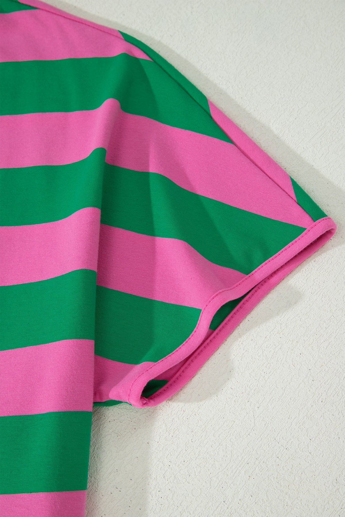 Manche de t-shirt rayé vert et rose, bordure rose et bandes horizontales