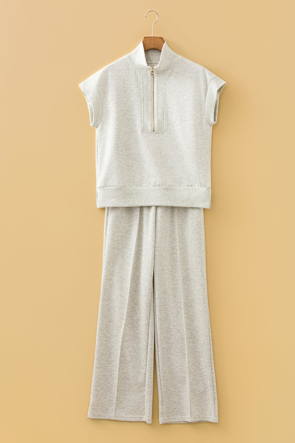 Ensemble polo zippé et pantalon large écru clair, sur cintre