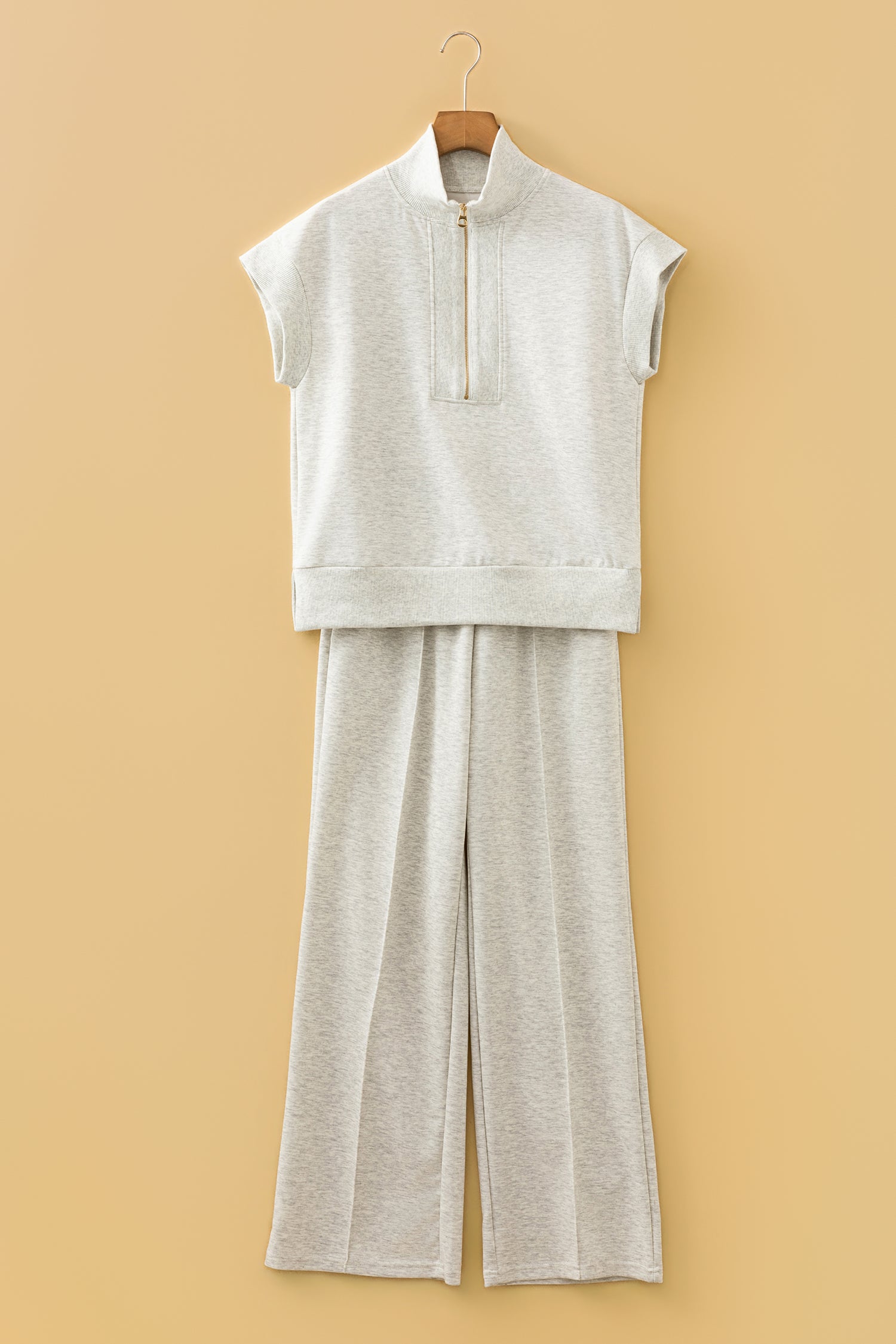 Ensemble polo zippé et pantalon large écru clair, sur cintre