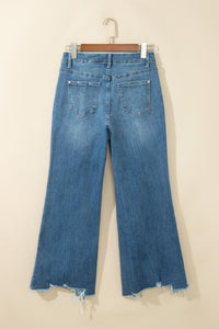 Jean flare taille haute bleu moyen, poches dos, ourlet effiloché avec bords usés.