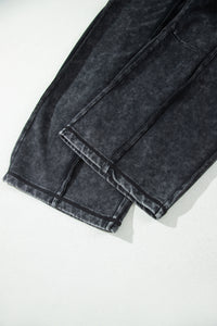 Bas de pantalon noir délavé minéral avec couture brute et ourlet retroussé, jambes larges
