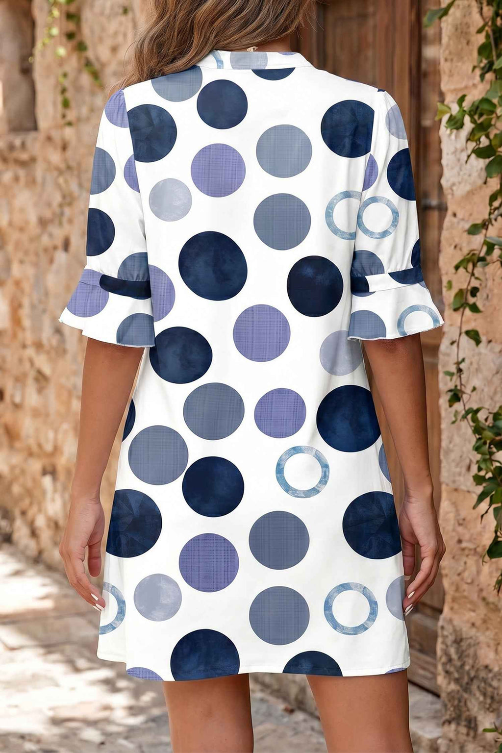 Robe mini à pois bleus et gris, vue de dos, manches courtes évasées, coupe droite.