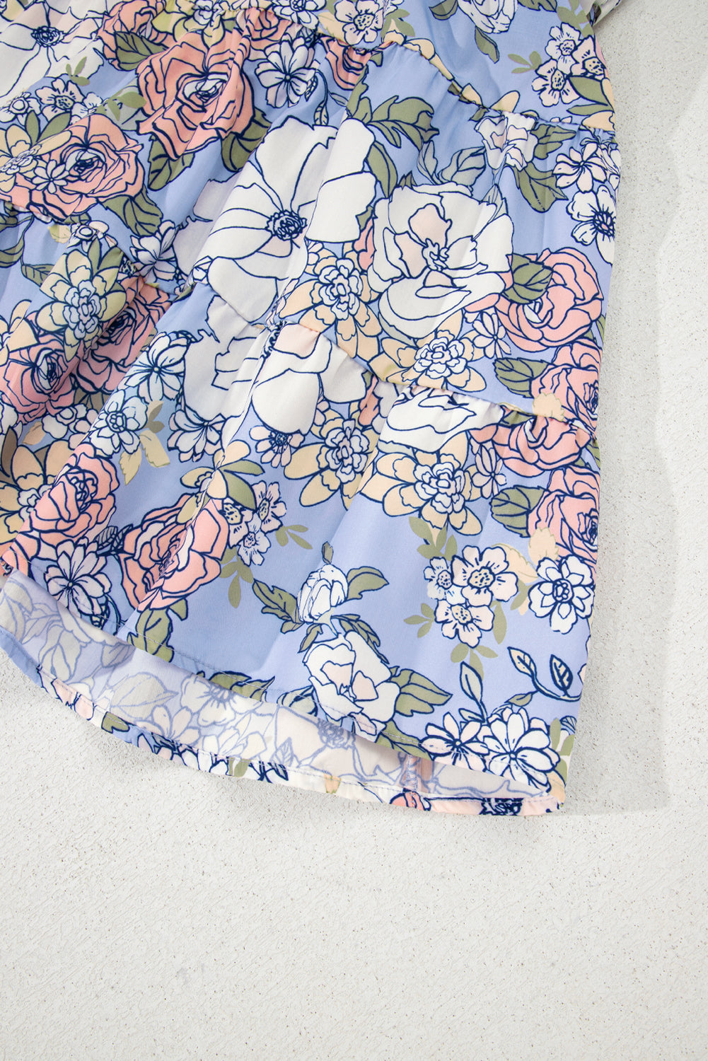 Ourlet de robe bleu ciel à motif floral pastel, bord légèrement froncé