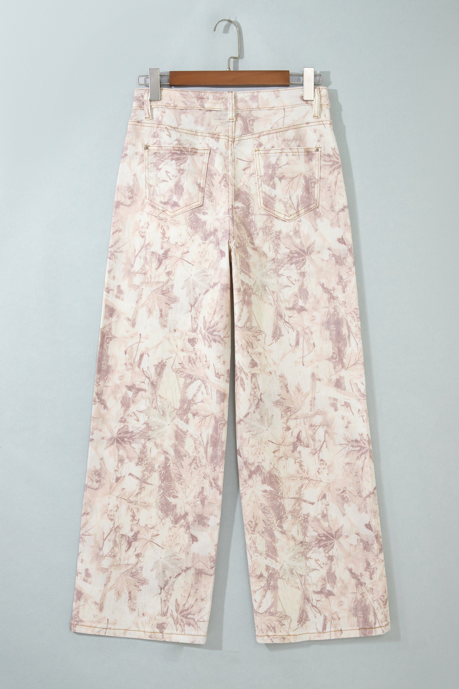 Jean large femme à motif camouflage rose clair, poches avant, jambes amples.