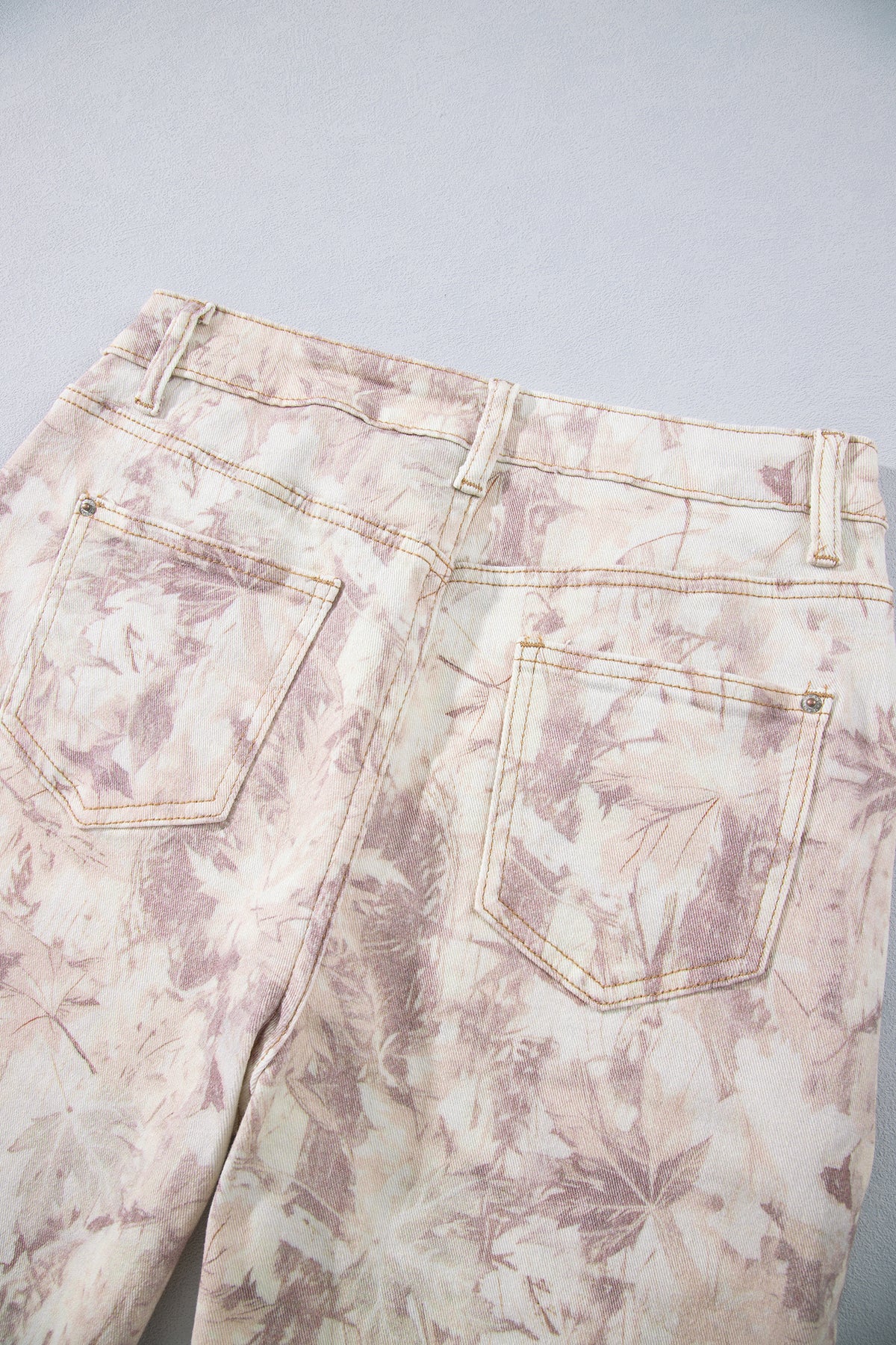 Jean large femme en toile motif camouflage rose clair, gros plan sur la taille.