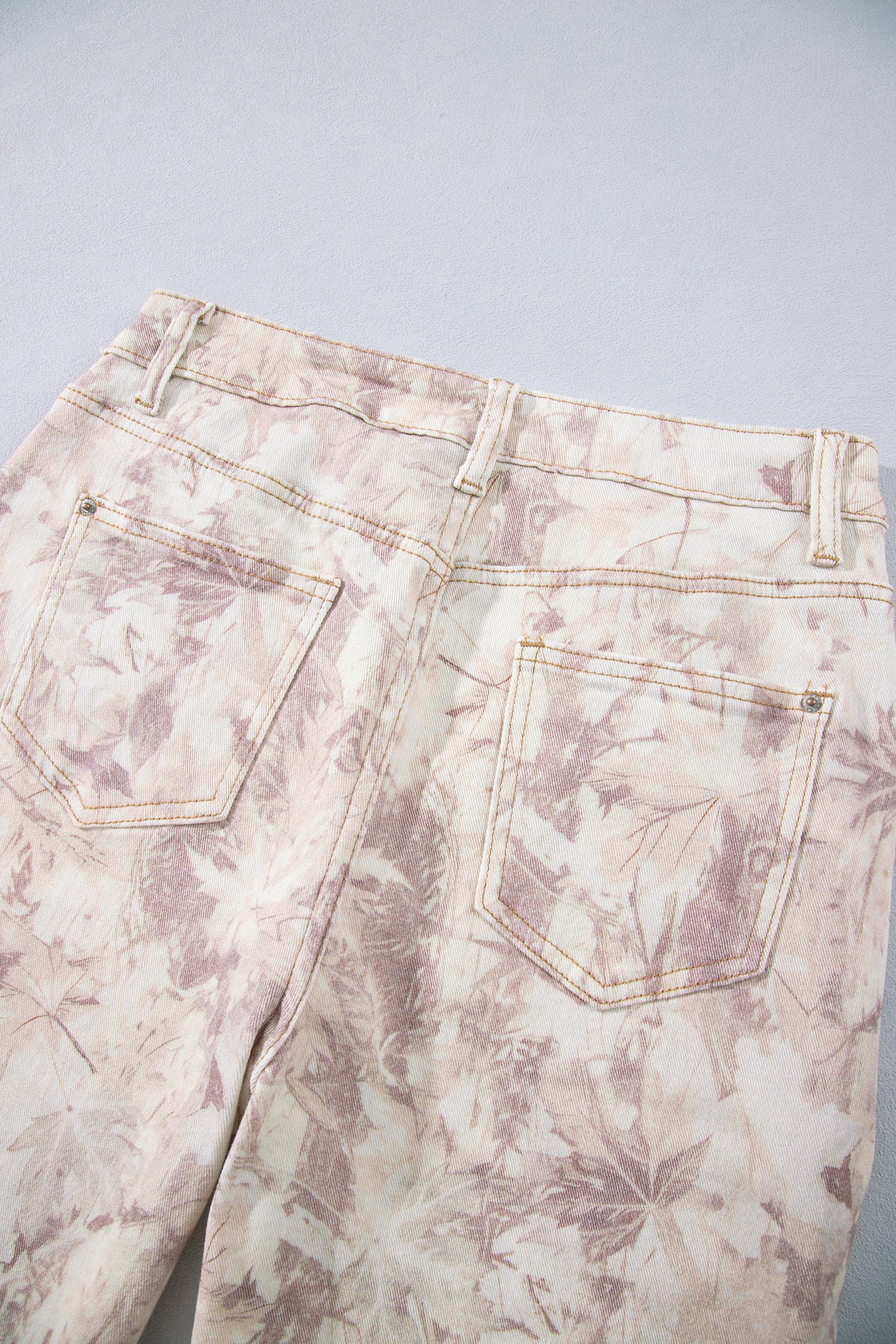 Jean large femme en toile motif camouflage rose clair, gros plan sur la taille.