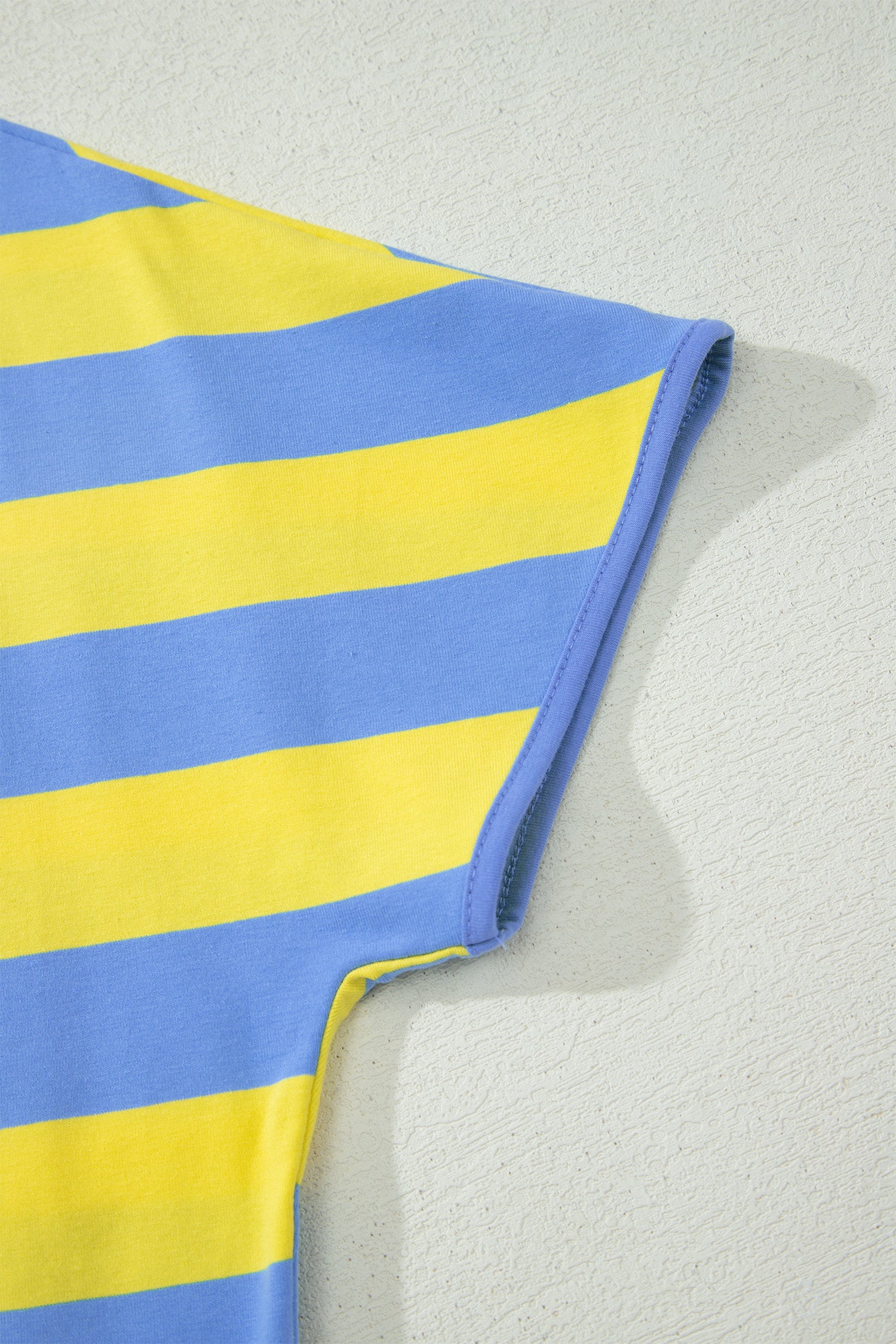 Manche et épaule du t-shirt rayé bleu et jaune, ourlet avec surpiqûres