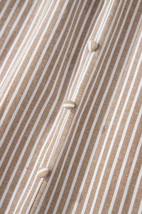 Détail de robe rayée : tissu texturé et boutons alignés au centre.