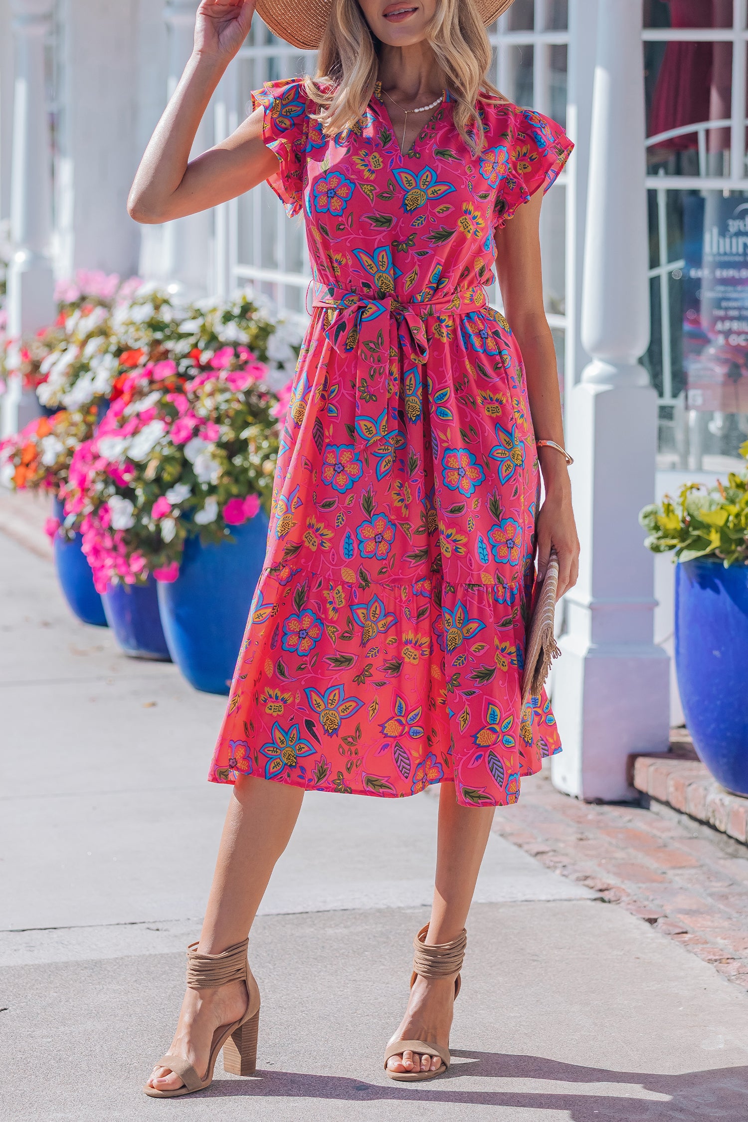 Robe longue fuchsia fleurie, ceinture à nouer, manches volantées, pose de face.