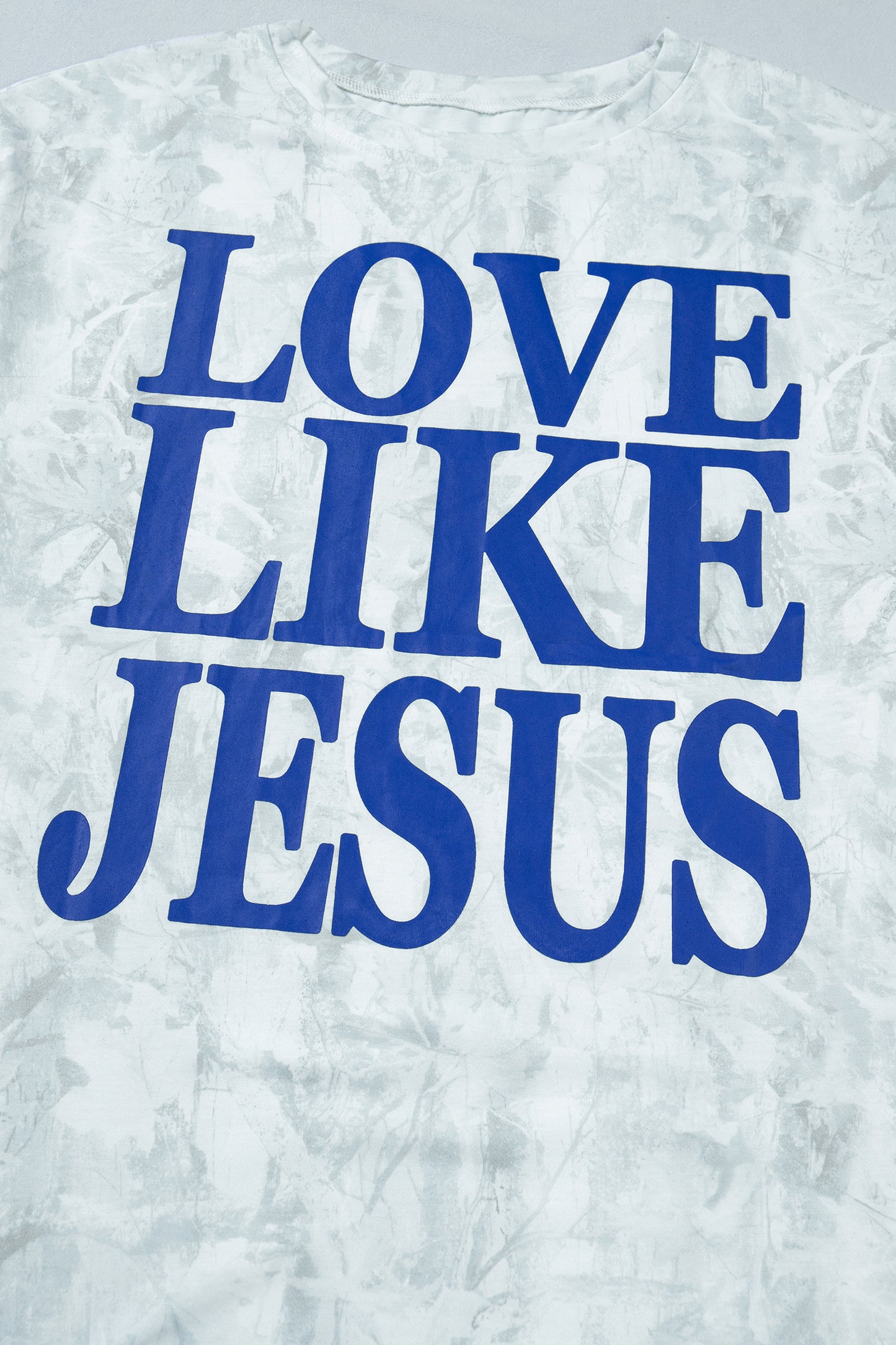 T-shirt oversize clair, lettrage bleu « LOVE LIKE JESUS » en gros, motif texturé