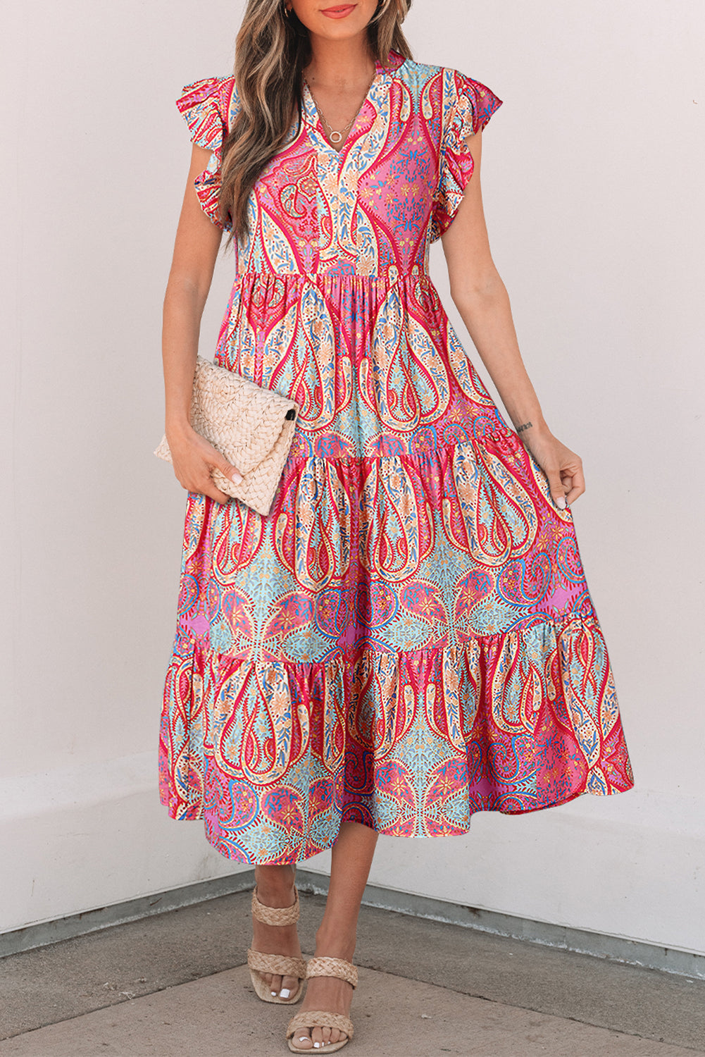 Robe mi-longue rose motif paisley, col en V, manches volantées, taille froncée, jupe étagée.