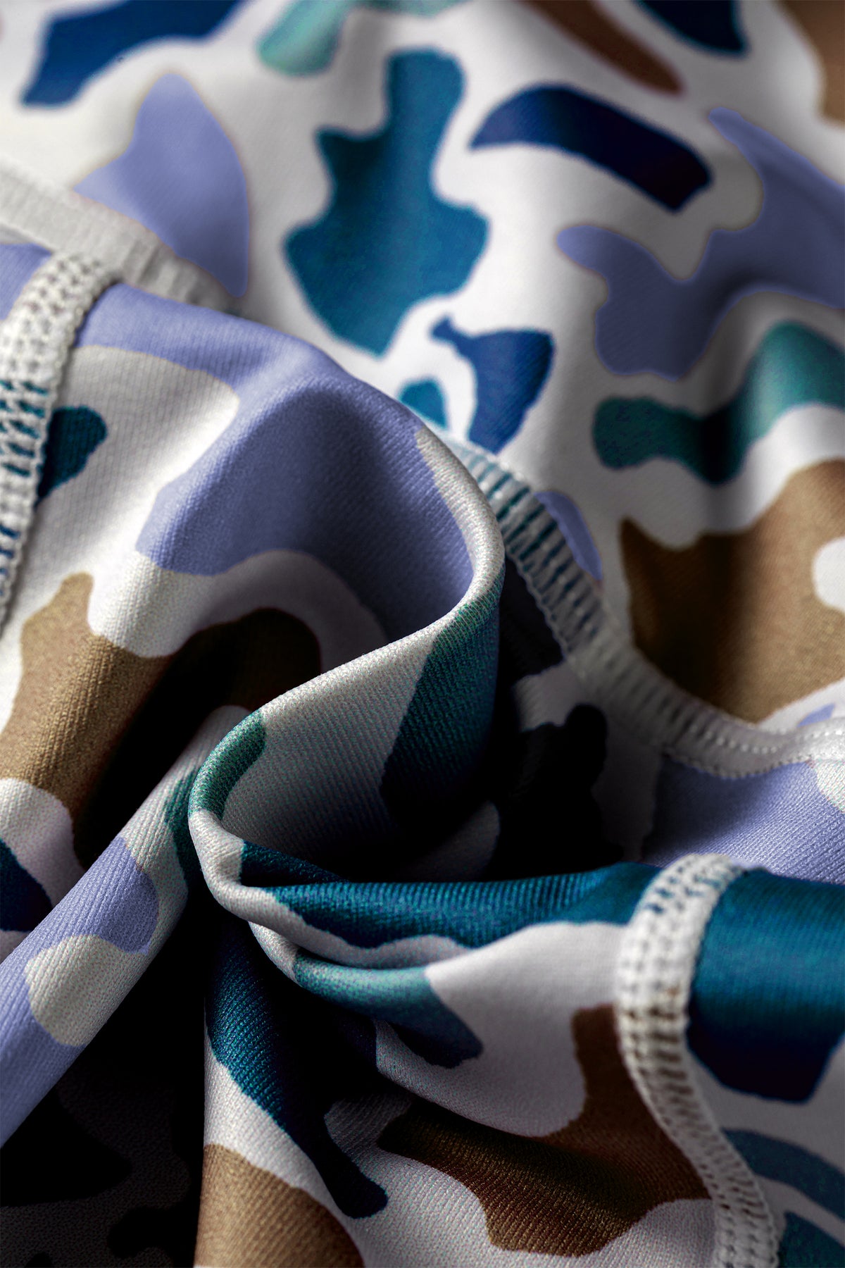 Tissu du short cycliste imprimé camouflage bleu, froissé près de la ceinture élastique.