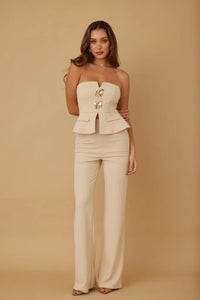 Ensemble deux pièces : bustier blanc froissé et pantalon long, bijoux dorés au buste