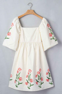 Robe babydoll crème imprimée de fleurs rouges, encolure carrée et manches bouffantes.