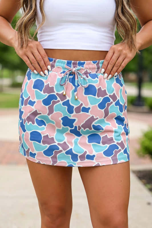 Jupe femme taille élastique imprimé camouflage bleu, turquoise et rose, au-dessus du genou.