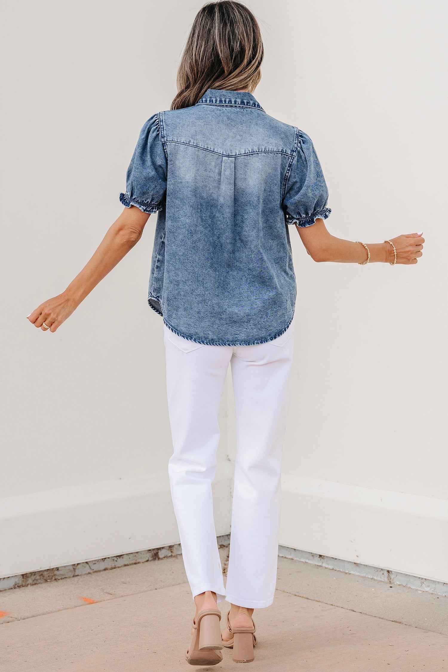 Chemisier en denim bleu, vue dos, manches bouffantes et rangée de boutons.