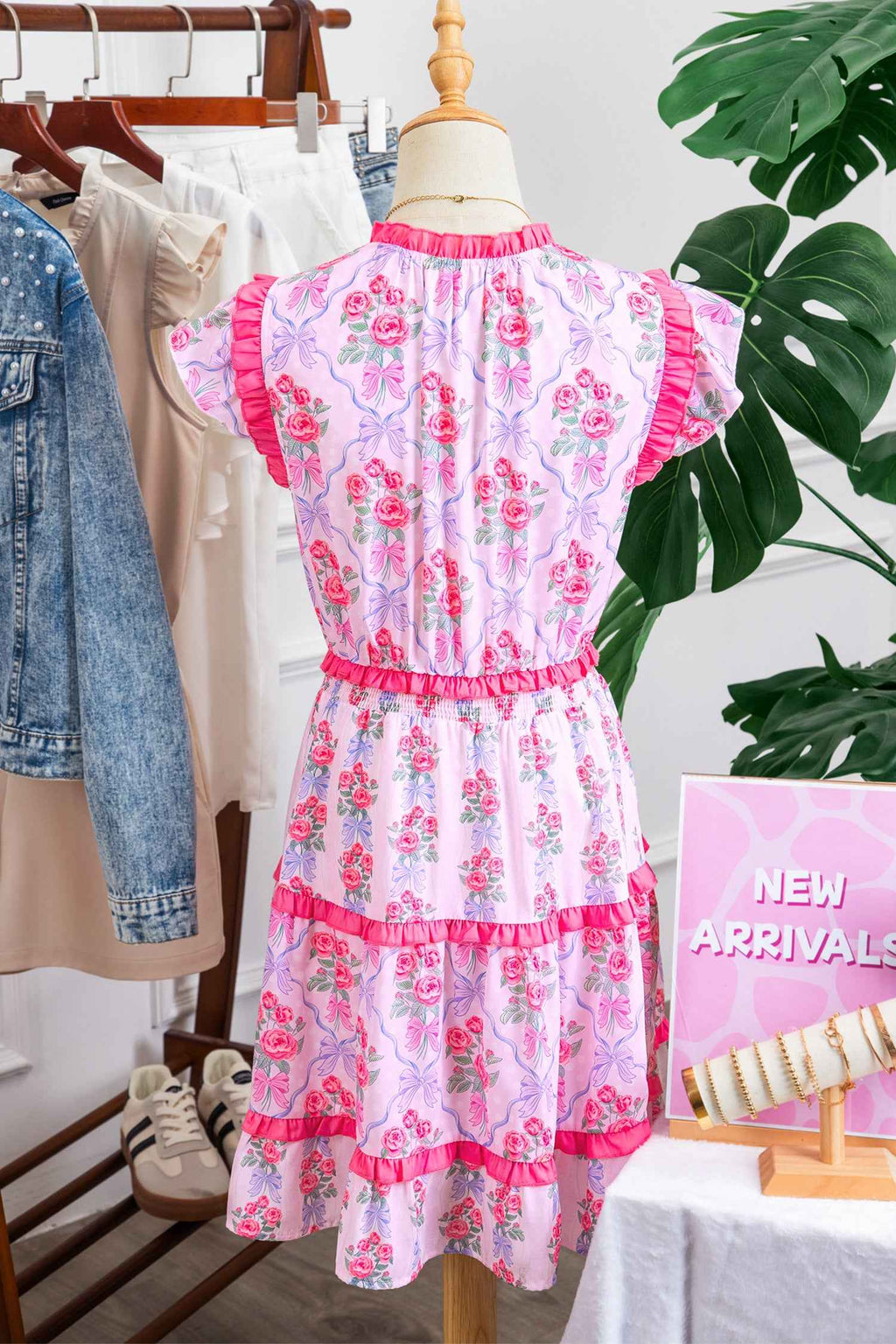 Robe florale sans manches à volants étagés sur cintre, fleurs roses sur fond bleu clair