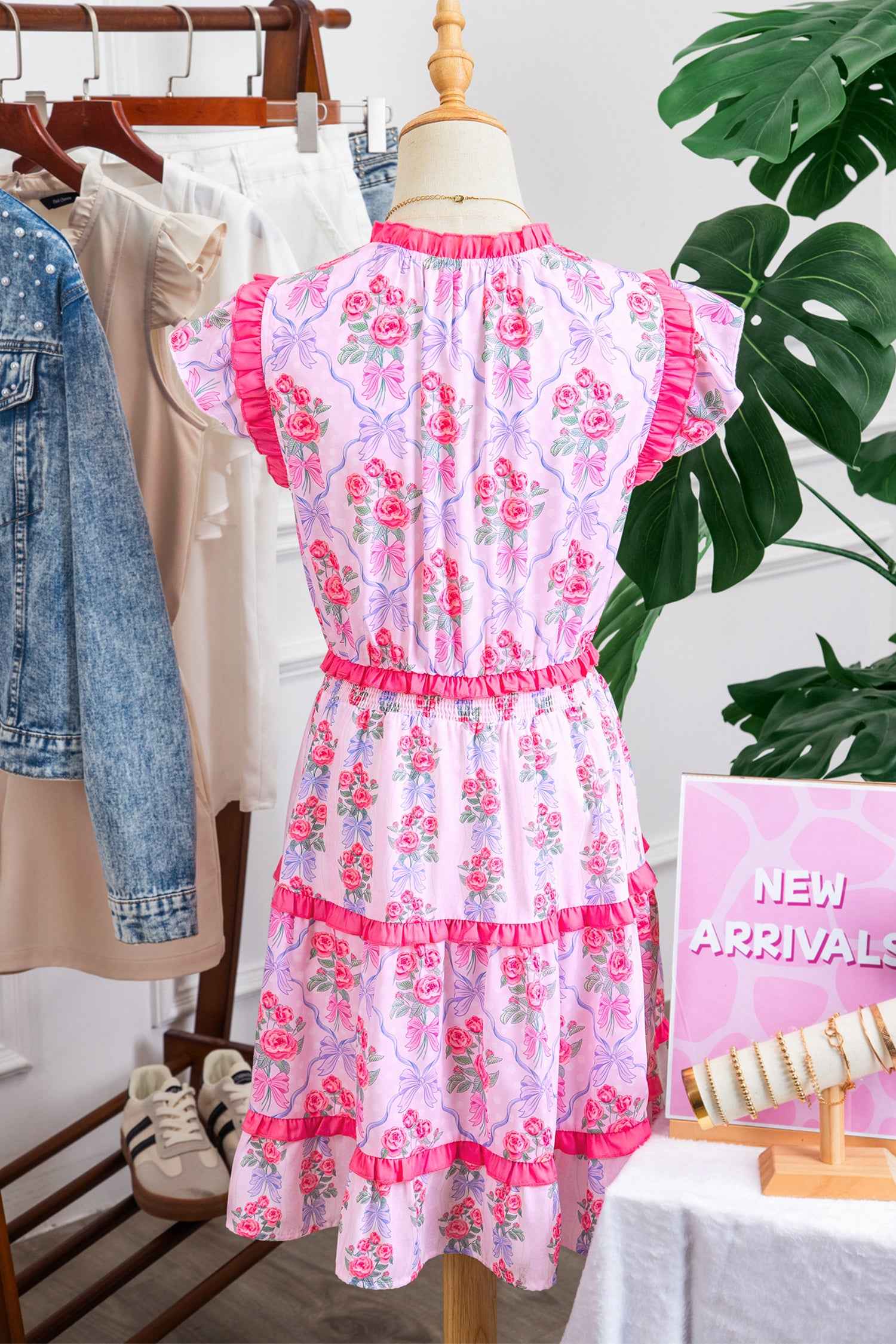 Robe florale sans manches à volants étagés sur cintre, fleurs roses sur fond bleu clair