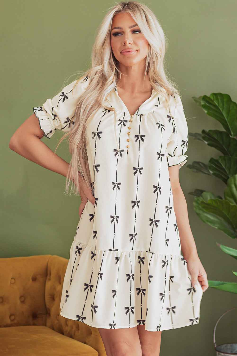 Robe courte crème à nœuds papillon, manches bouffantes, volants superposés.