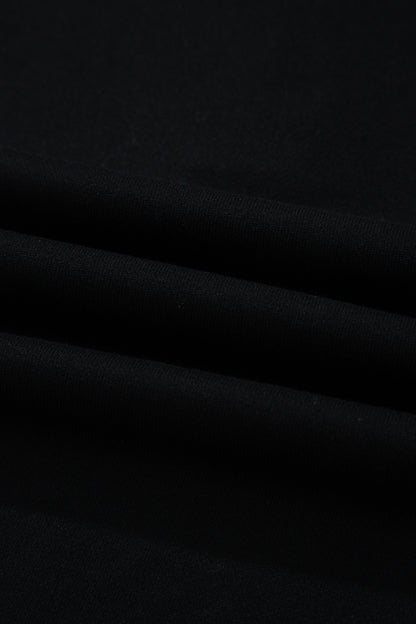 Haut polo bicolore en denim, détail du tissu noir avec plis légers.