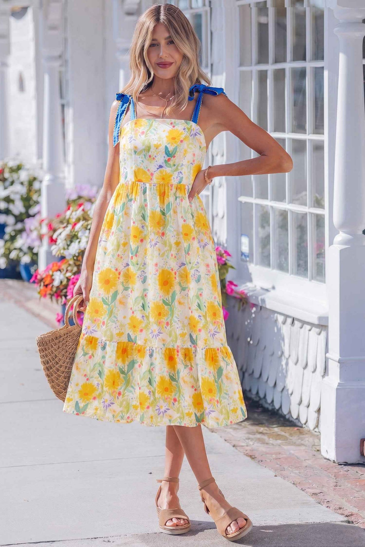 Robe midi à bretelles fines, imprimé floral jaune, nœuds bleus sur les épaules.