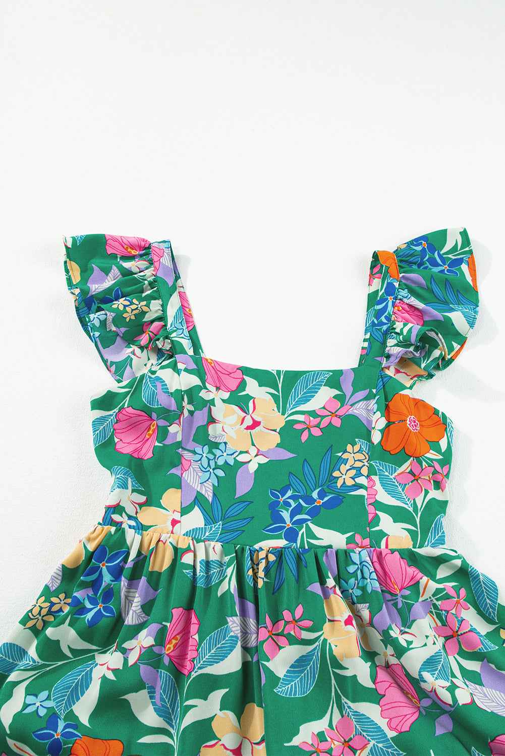 Robe longue florale verte, encolure carrée, volants d’épaules et taille froncée.