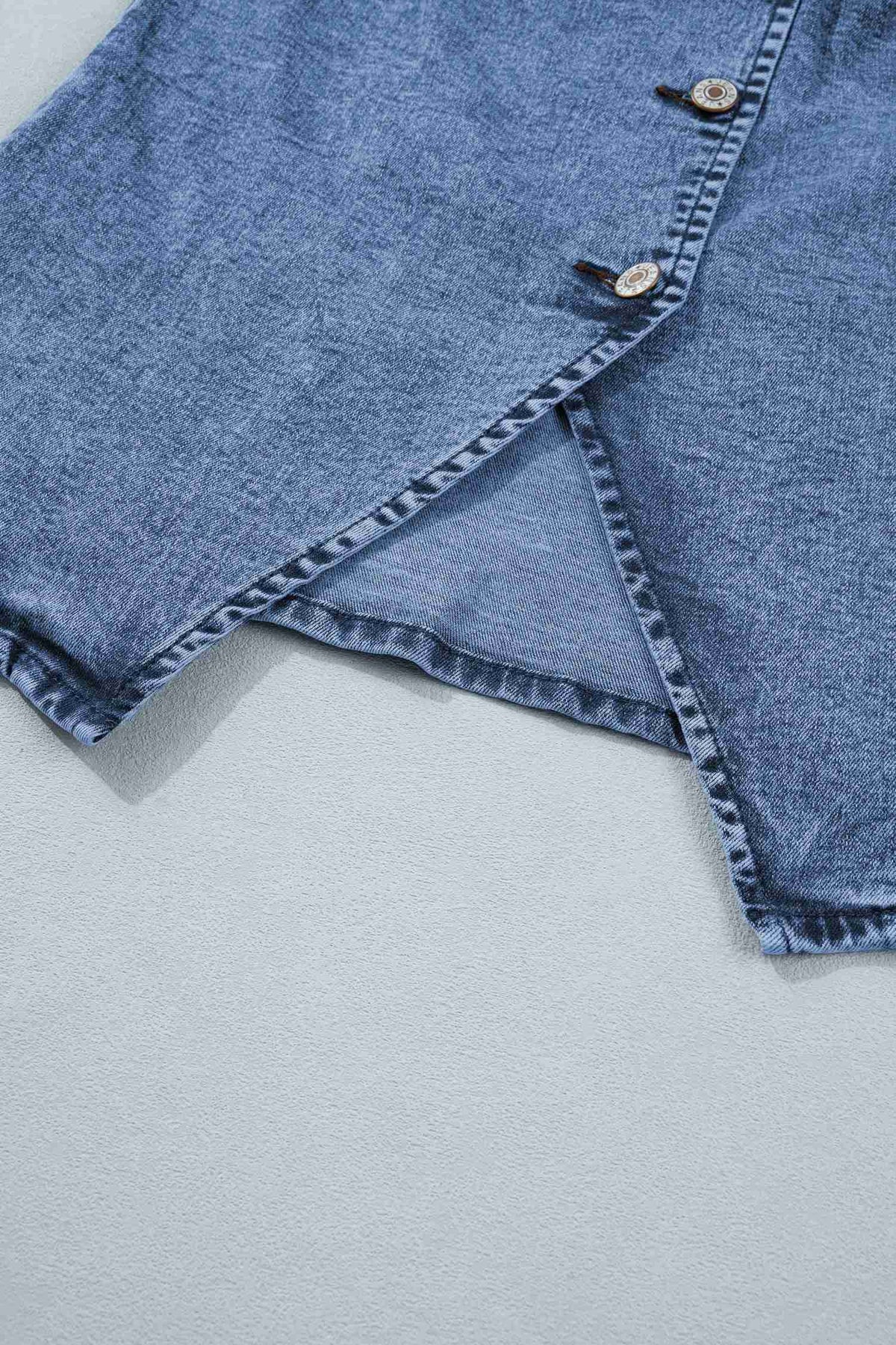 Bas fendu du gilet en denim bleu sans manches avec coutures et surpiqûres décoratives