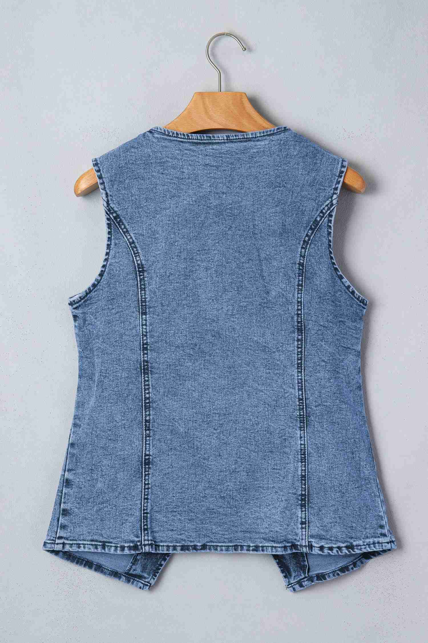 Gilet en denim bleu sans manches, dos uni avec coutures verticales, sur cintre