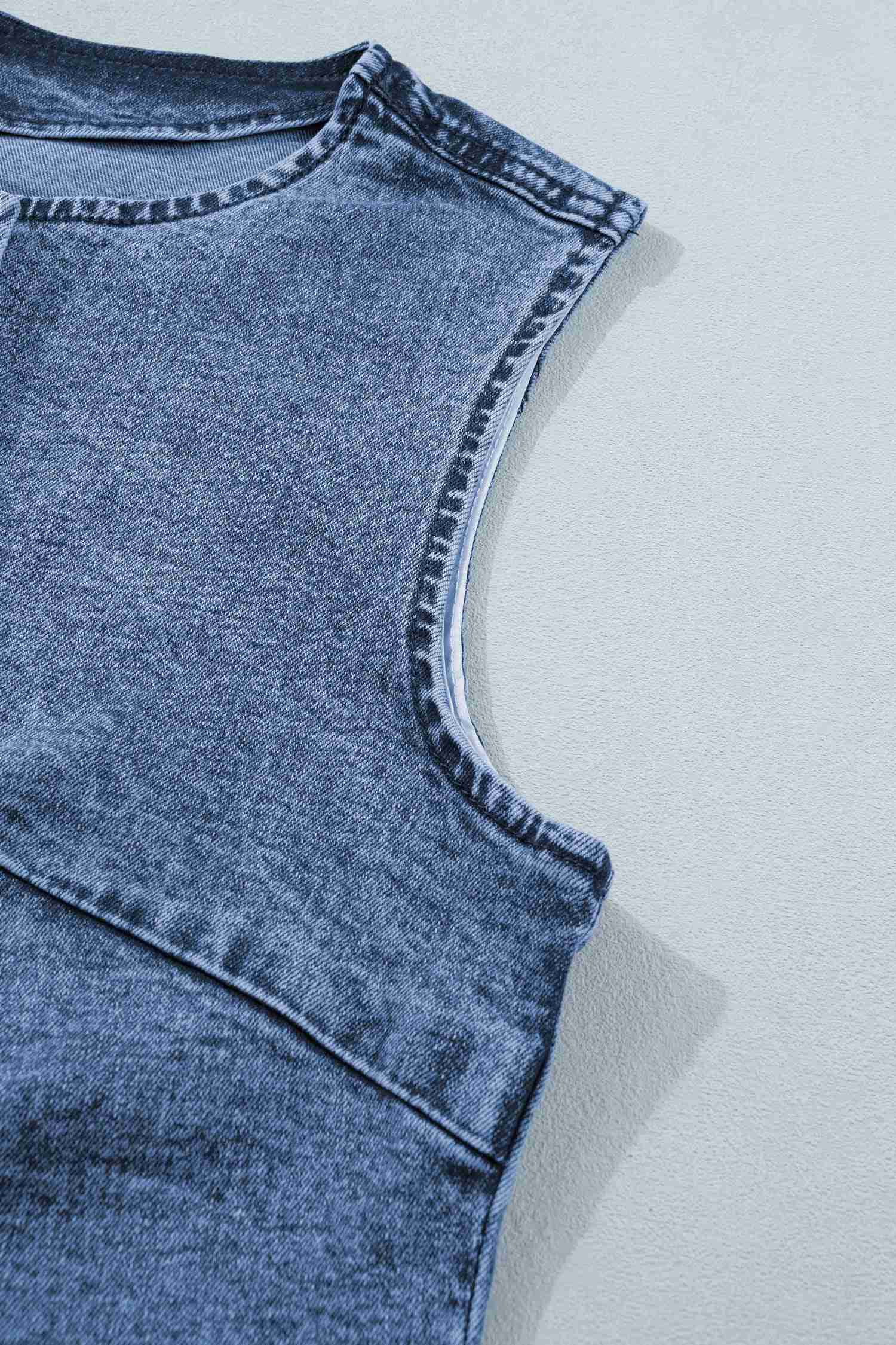 Encolure et emmanchure du gilet en denim bleu sans manches, surpiqûres visibles