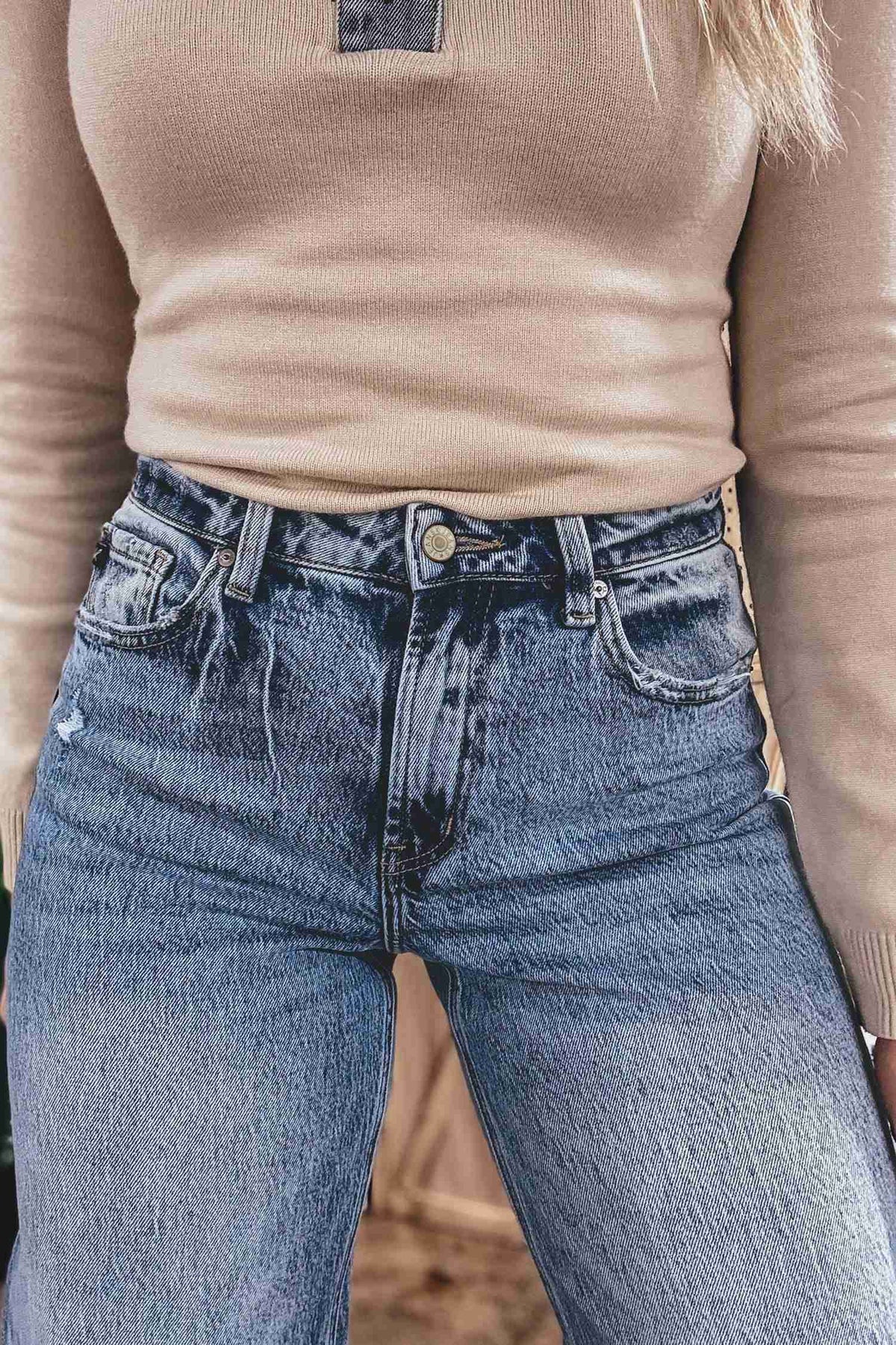 Jean bleu moyen ample droit à taille mi-haute, boutons et poches poitrine visibles