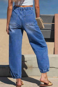 Jean bleu taille haute fuselé, poche avant, surpiqûres, ourlet resserré.