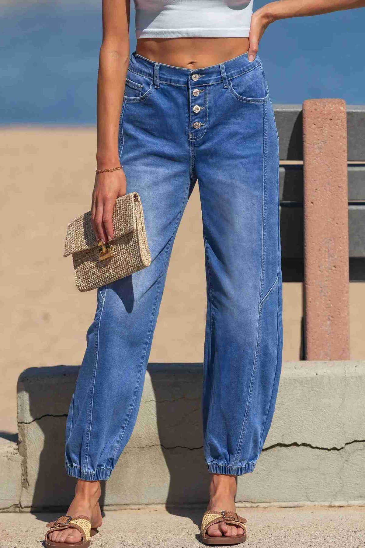 Jean bleu taille haute fuselé, 4 boutons devant, poches, bas resserré.