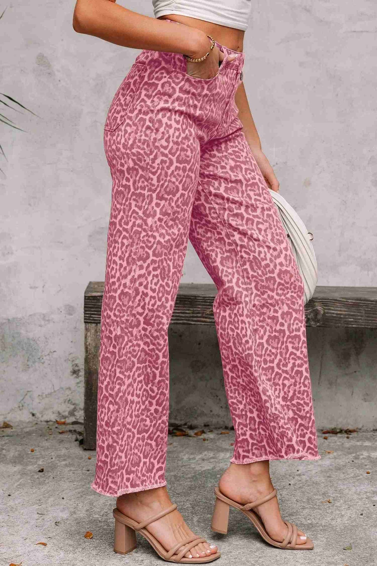 Jean taille haute rose imprimé léopard, jambes évasées et bords effilochés au bas
