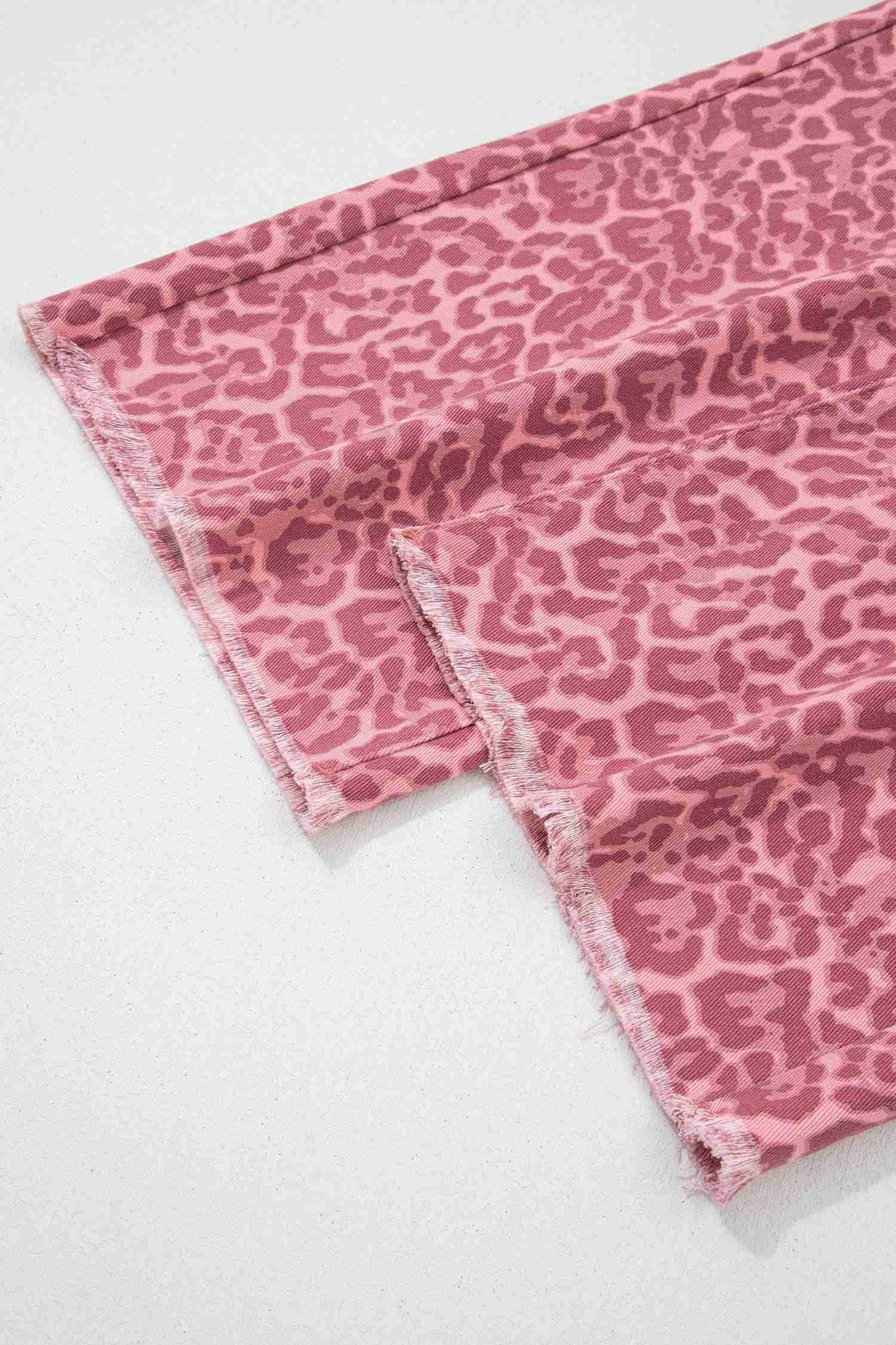 Détail du bas: tissu rose imprimé léopard avec ourlet effiloché