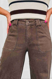 Jean femme marron délavé, poches plaquées et bouton à la taille, couture visible.