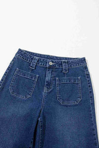 Jean bleu taille haute ample, gros plan poches arrière et ceinture boutonnée.