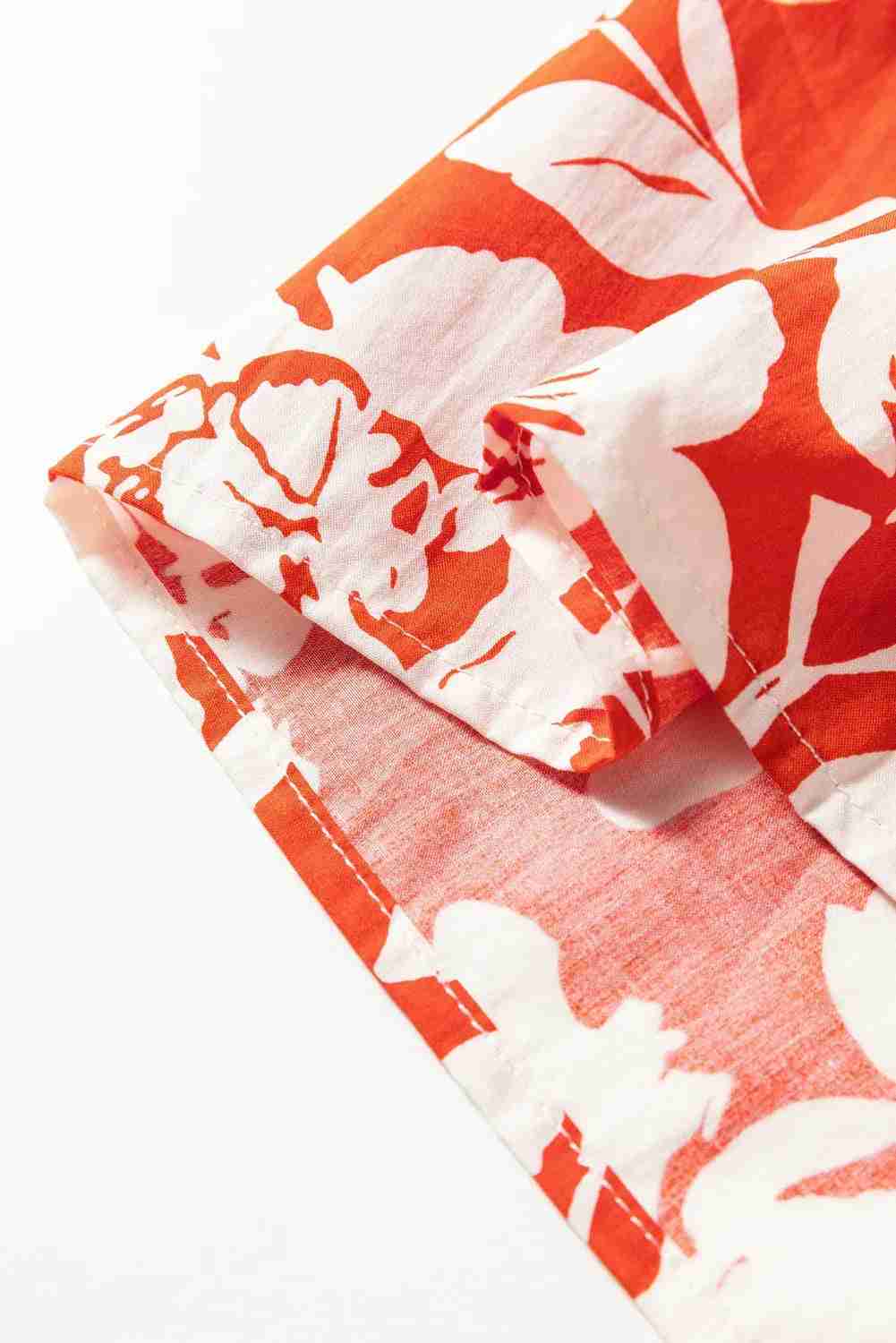 Jupe en tissu rouge à fleurs blanches, détail du pli et de la couture