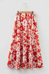 Jupe longue rouge à fleurs blanches, taille élastique froncée et volantée