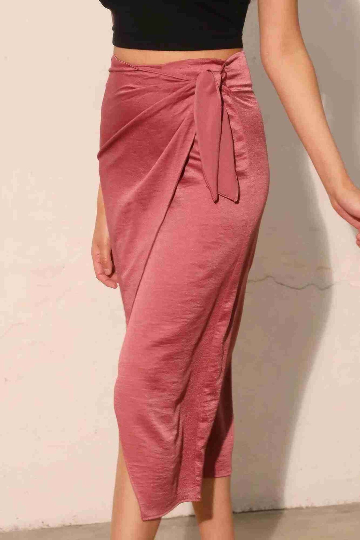 Jupe midi portefeuille satin crêpe lavé rose, lien noué sur le côté, fente devant.