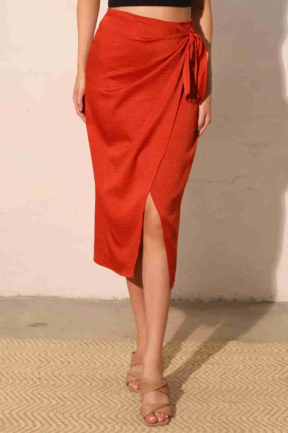 Jupe midi portefeuille satin crêpe lavé rouge, lien noué sur le côté, fente.