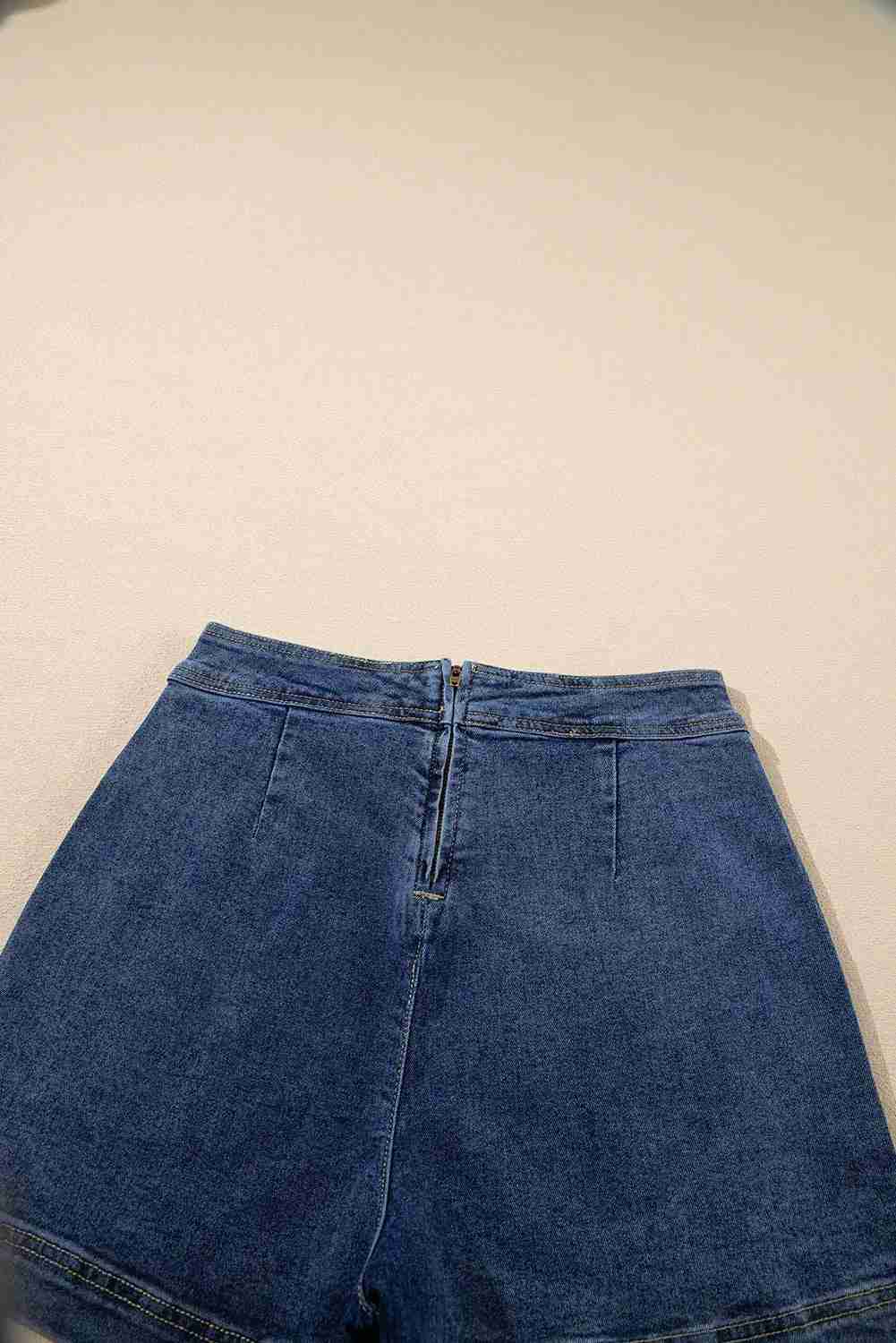 Jupe-short en jean bleu, fermeture centrale et surpiqûres, taille mi-haute