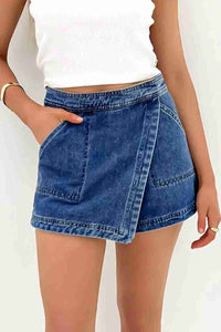 Jupe-short en jean bleu effet portefeuille, coutures marquées et boutonnage discret